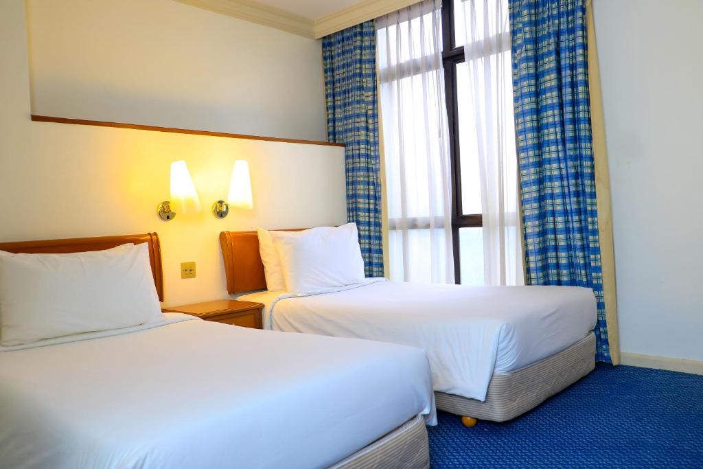 Postel nebo postele na pokoji v ubytování Merdeka Palace Hotel & Suites