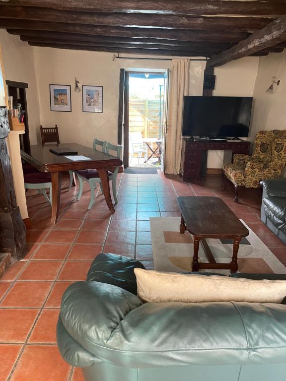 a living room with a couch and a tv at Lavender Cottage in Chézelles