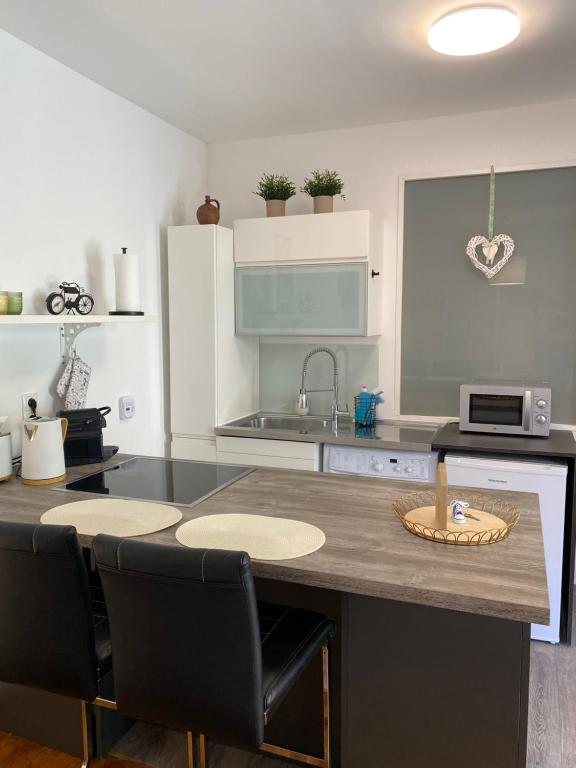uma cozinha com uma ilha de cozinha com cadeiras e um balcão em Studio im Wienerwald - Mödling em Mödling