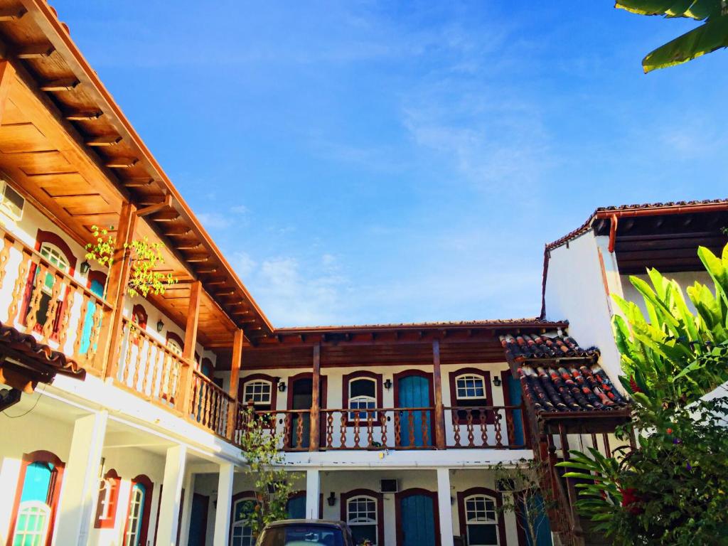 una casa antigua con un balcón en el lateral. en Pousada Marques, en Paraty