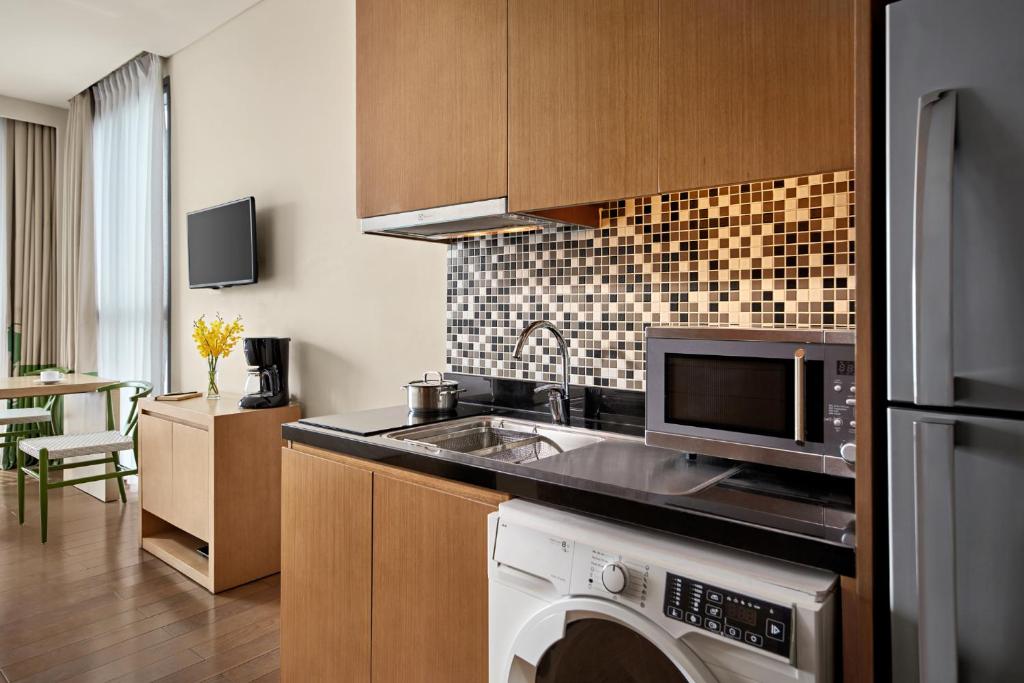 A compact apartment-style kitchen with laundry facilities beside the living area.