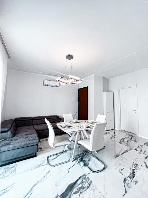 a white living room with a table and chairs at Luxuriöse Wohnung in Herzens von Sanremo in Sanremo