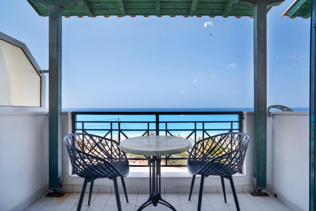 un tavolo e sedie su un balcone con vista sull'oceano di Sunset Triple 1 a Ayios Nikitas