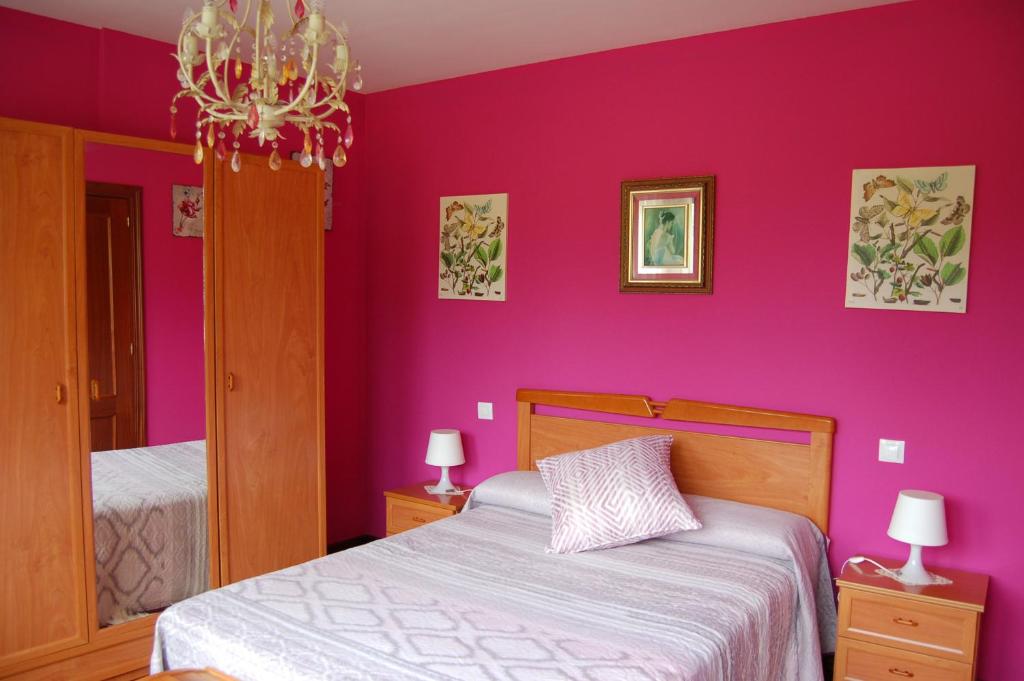 a purple bedroom with a bed and a chandelier at Casa el patio in Ampuero