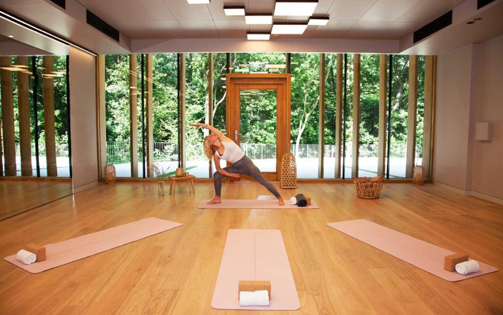 a woman doing a yoga pose in a room with yoga mats at Hotel Arima & Spa - Small Luxury Hotels in Donostia-San Sebastián