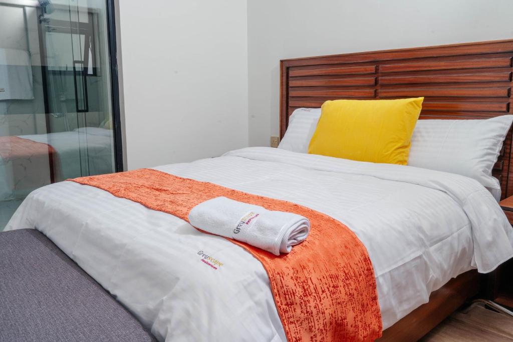a bed with two towels sitting on top of it at Greyscape Apple Tree Apartment in Nairobi