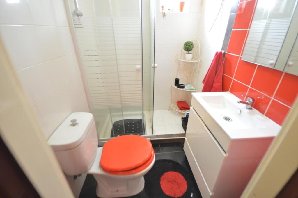 a bathroom with a toilet and a shower and a sink at Casa 33 in Lagos