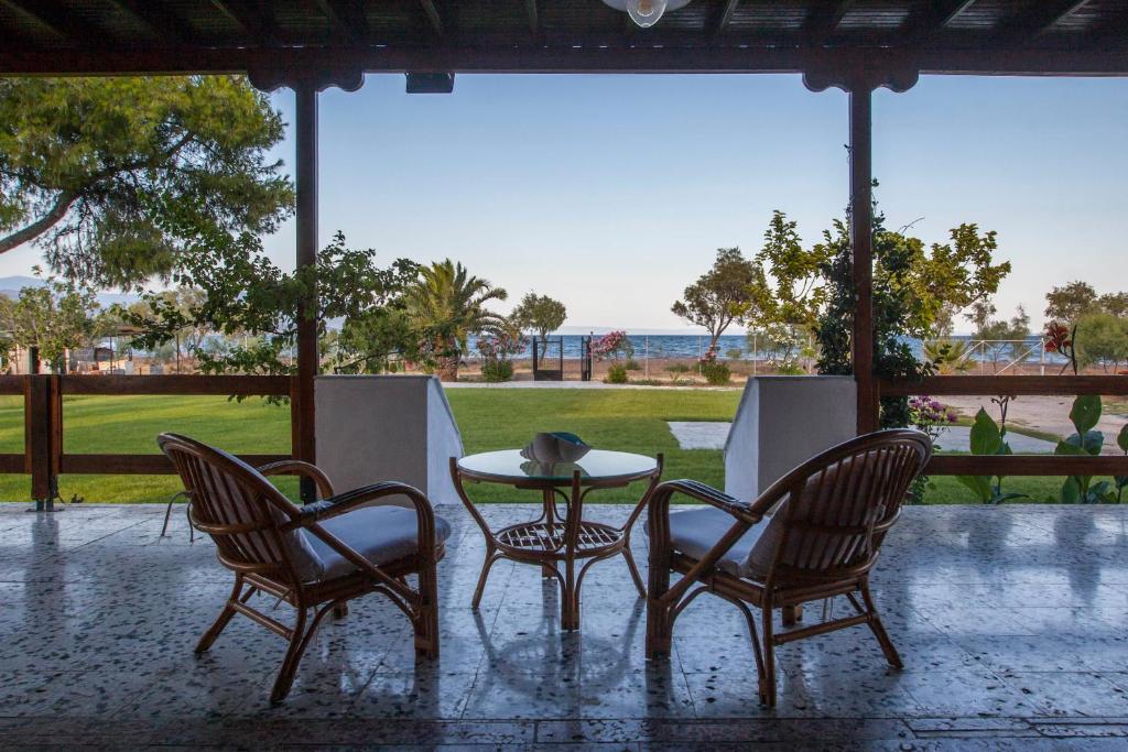 a table and two chairs and a table and a table and chairs at ThemiLia Beachfront, Luxury House in Néa Ankhíalos