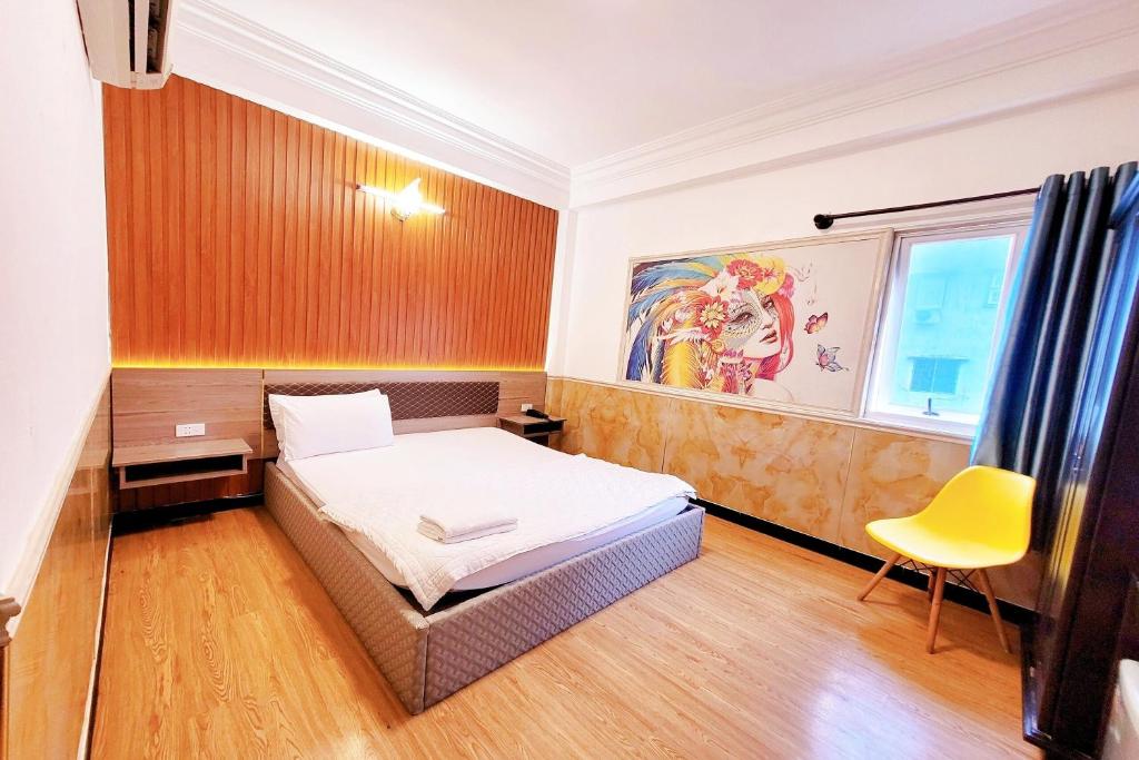 a bedroom with a bed and a yellow chair at Hoang Nam Hotel in Ho Chi Minh City
