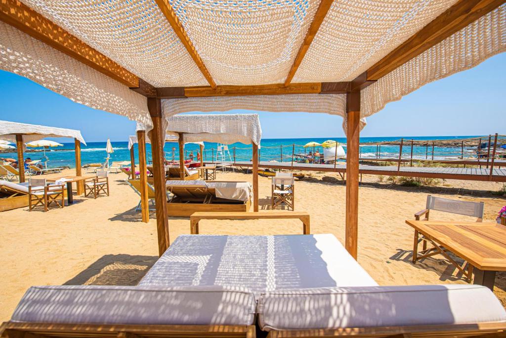 a beach with tables and chairs and the ocean at Pietrablu Resort & Spa - CDSHotels in Polignano a Mare