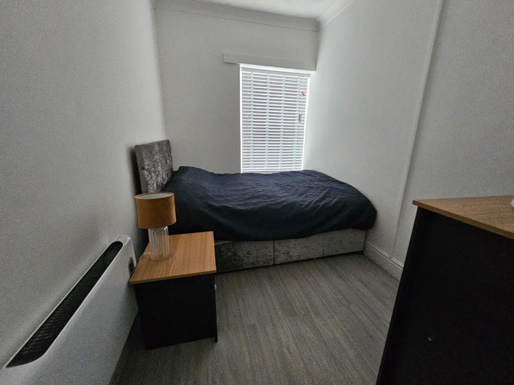 a small bedroom with a bed and a window at Flat - Sleeps 4 - WiFi in Bridgend