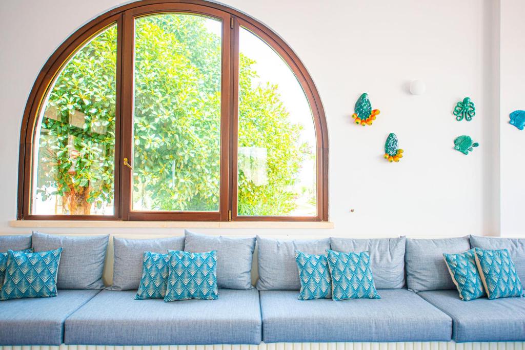 a blue couch with blue pillows in a living room at Pietrablu Resort & Spa - CDSHotels in Polignano a Mare