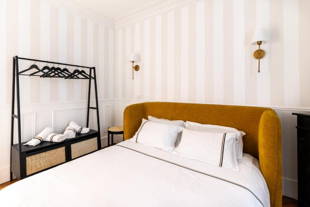 - une chambre avec un lit doté de draps blancs et d'oreillers blancs dans l'établissement Charming Parisian Flat near Eiffel Tower, à Paris