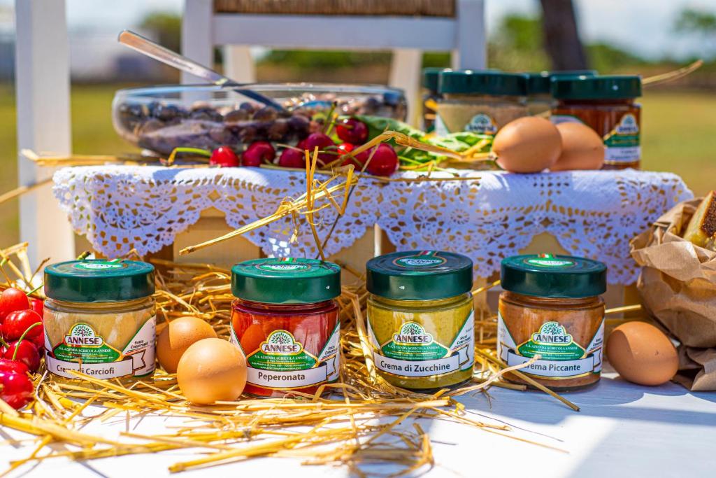 a table topped with jars of jam and vegetables at Pietrablu Resort & Spa - CDSHotels in Polignano a Mare