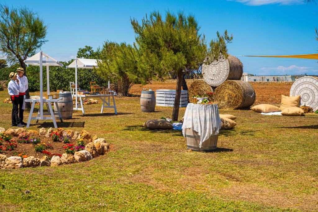 a woman standing next to a garden with sheep in a field at Pietrablu Resort & Spa - CDSHotels in Polignano a Mare