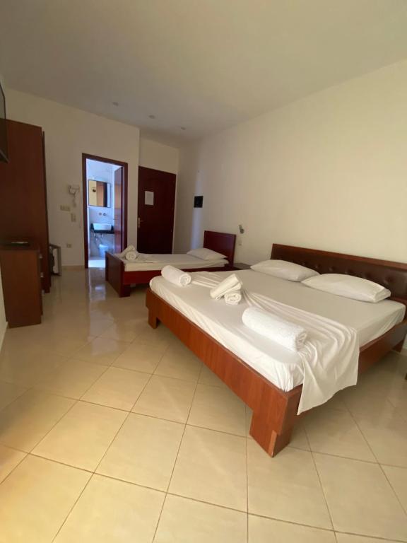 two beds in a large room with at Hotel Afrodite in Dhërmi