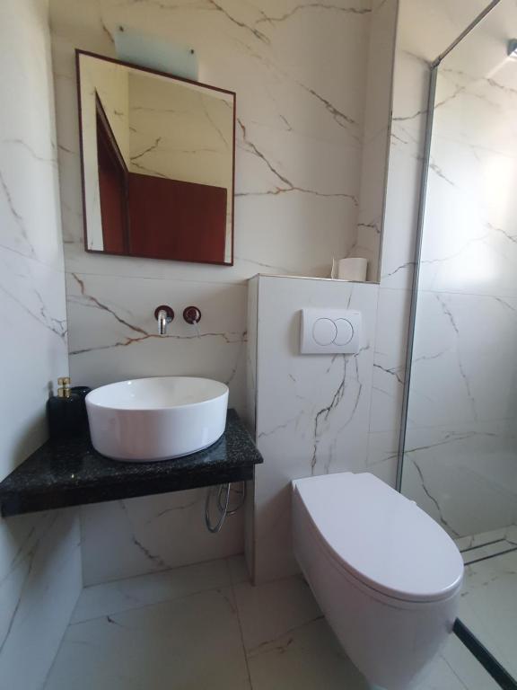 a bathroom with a sink and a toilet at Hotel Afrodite in Dhërmi