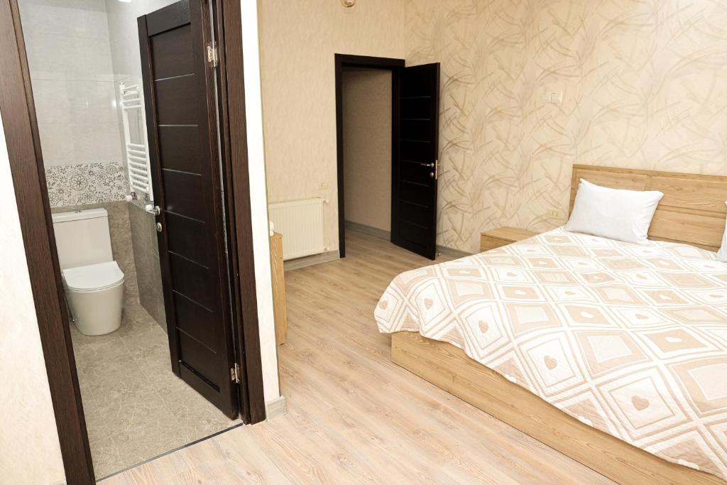 a bedroom with a bed and a bathroom with a toilet at Silent Apartment 1 in Yerevan