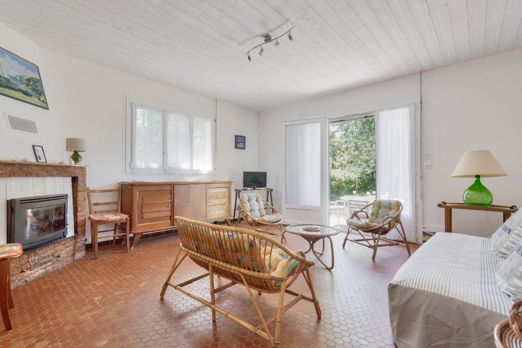 een woonkamer met een bed en een open haard bij À moins de 2km de la plage, maison pour 6 in Andernos-les-Bains