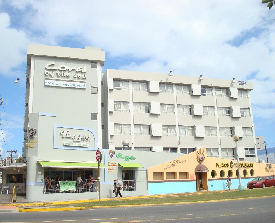 ein großes weißes Gebäude an der Ecke einer Straße in der Unterkunft Coral by the Sea in San Juan