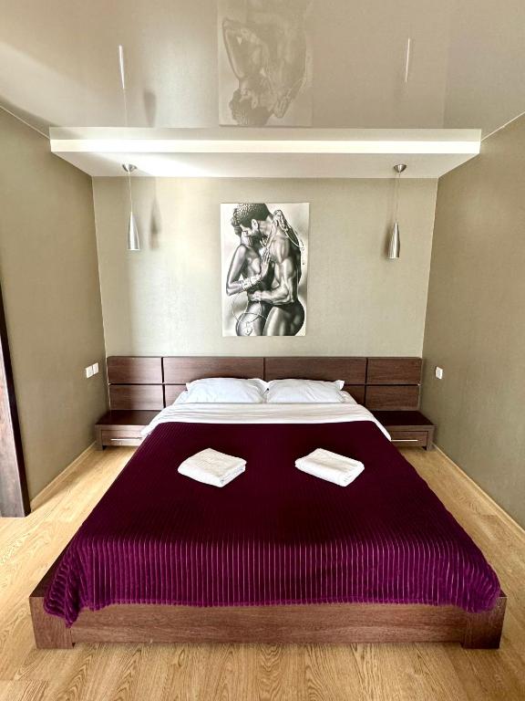 a bedroom with a large bed with a purple bedspread at Гоголя 68 in Karagandy
