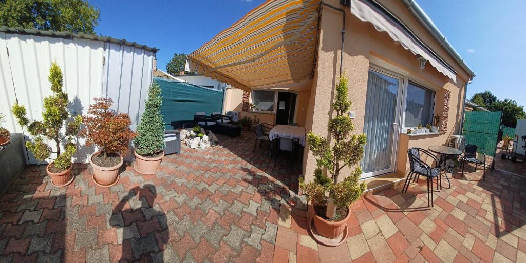 a patio with a bunch of potted plants on it at Tulipán Apartmanház in Bük