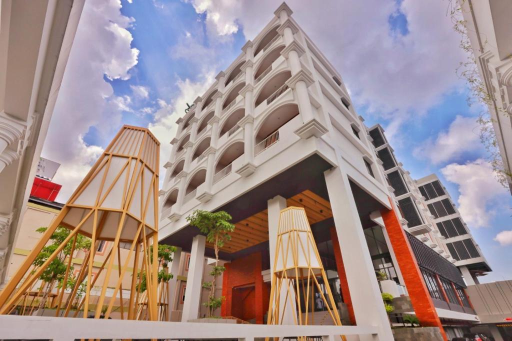 a white building with two umbrellas in front of it at Patra Malioboro Hotel in Yogyakarta