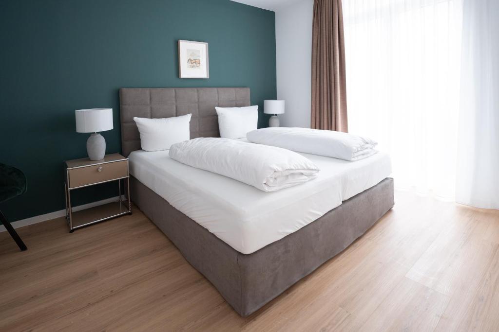 アシャッフェンブルクにあるSCHÖNTALHAUS City Apartmentsの白いシーツと枕が付いた大きなベッドのある寝室