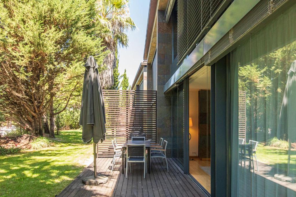 a patio with a table and an umbrella at VILLA FARHAT in Troia