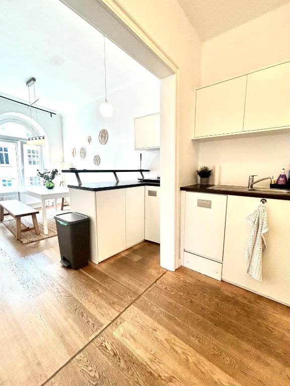 a kitchen and dining room with white cabinets and a table at Central Apartment for up to 10 Guests in Hamburg