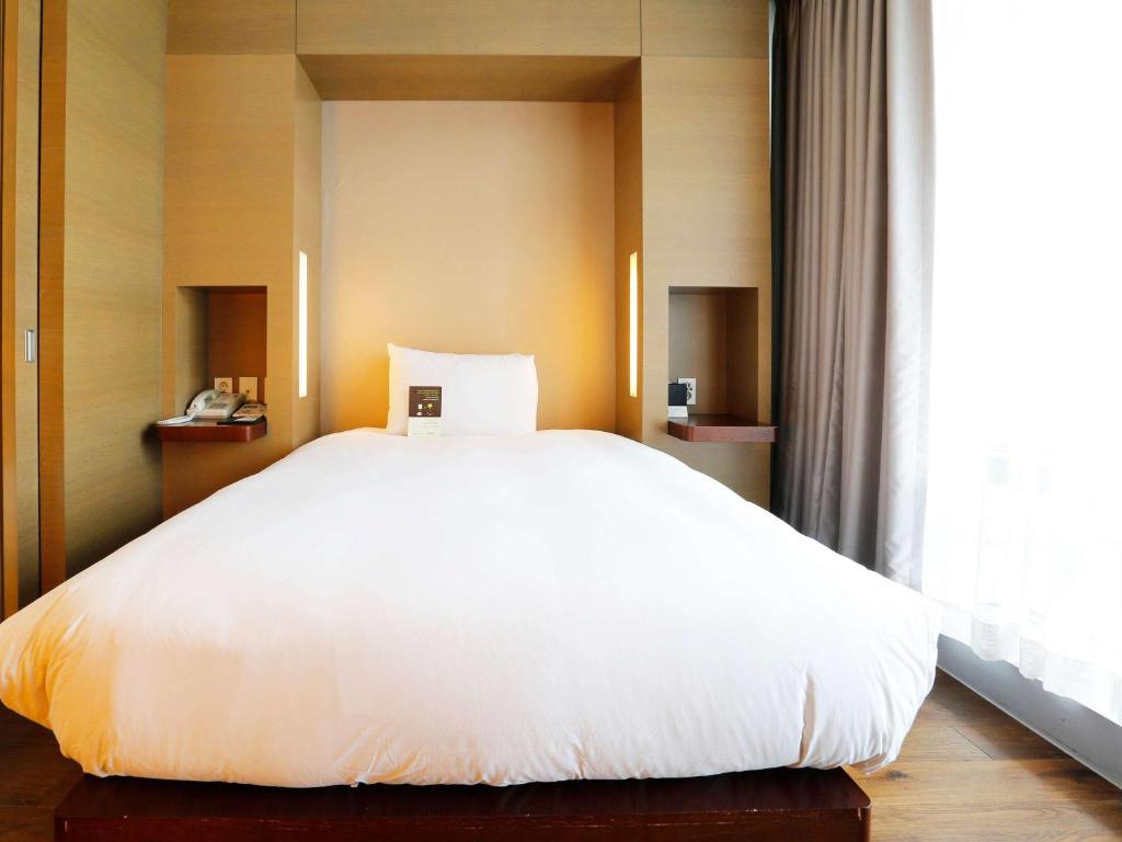 Postel nebo postele na pokoji v ubytování Grand Mercure Ambassador Changwon