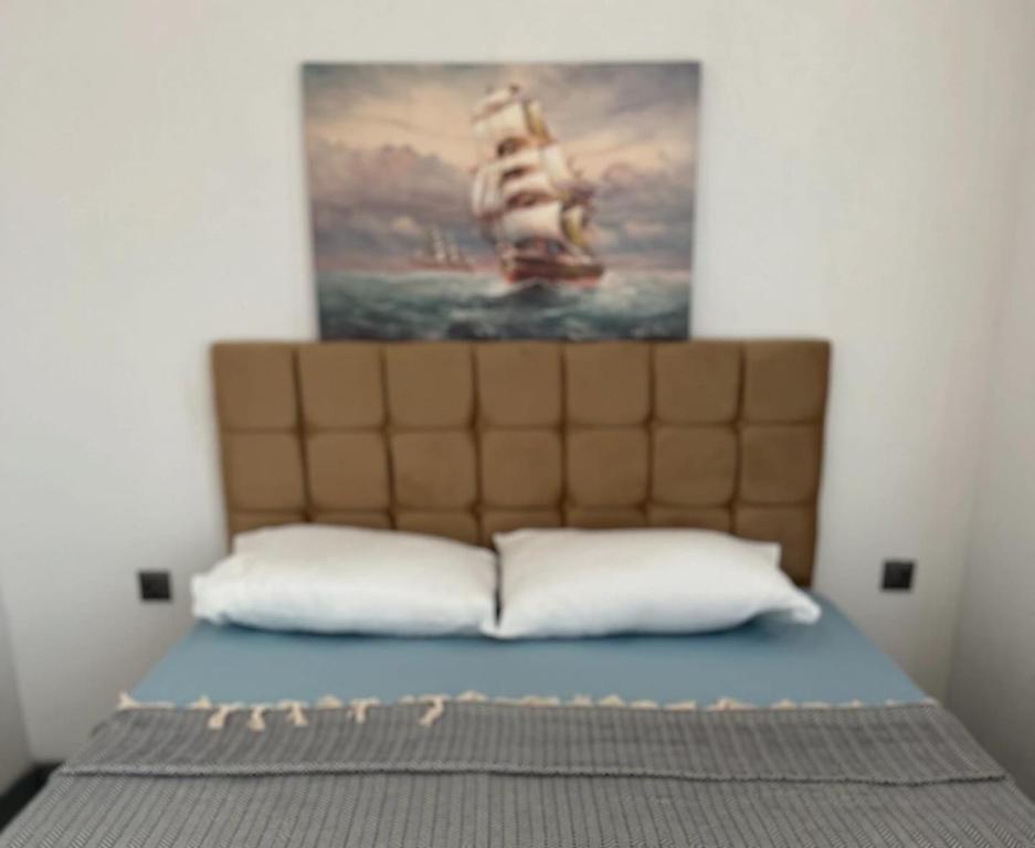 Un dormitorio con una cama con un cuadro en la pared. en Villa Badem Çiçeği, en Ayvacık