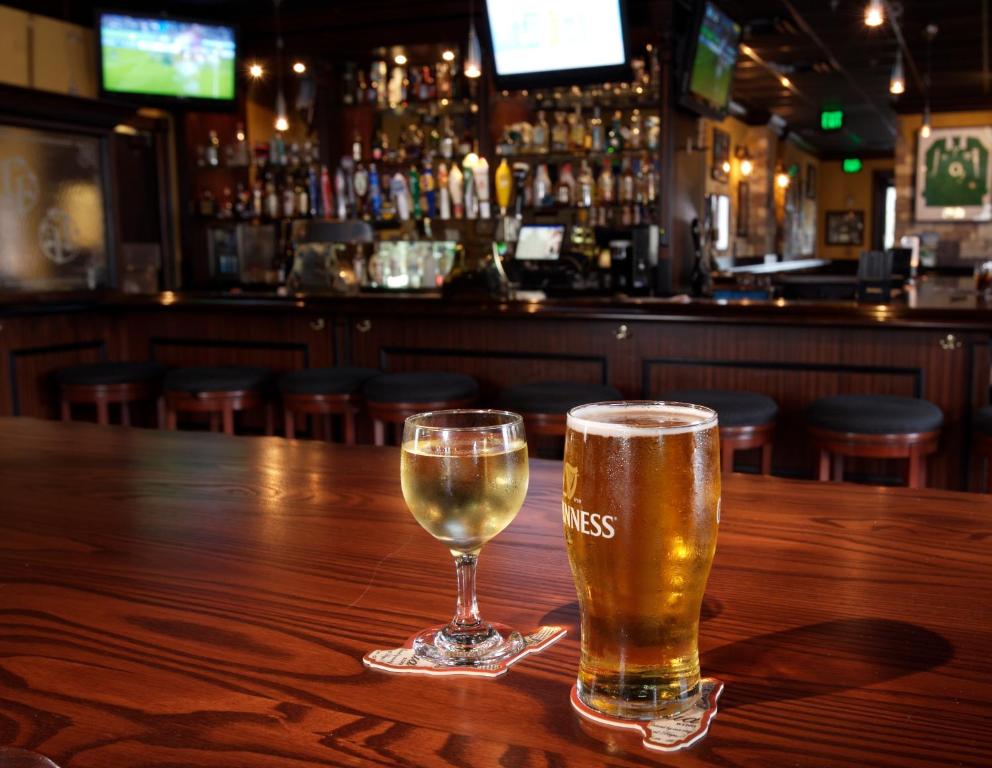 two glasses of beer sitting on a wooden table in a bar at Lake Buena Vista Resort Village and Spa, Near Disney in Orlando