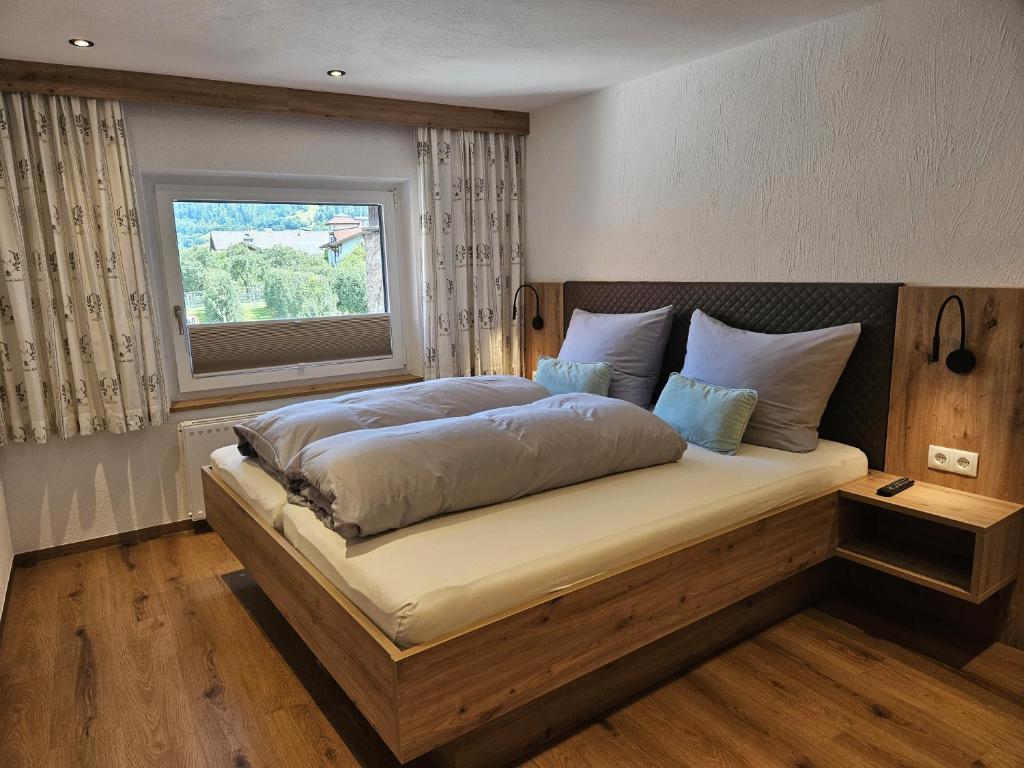 a bedroom with a large bed with a window at Haus Kathrein in Prutz
