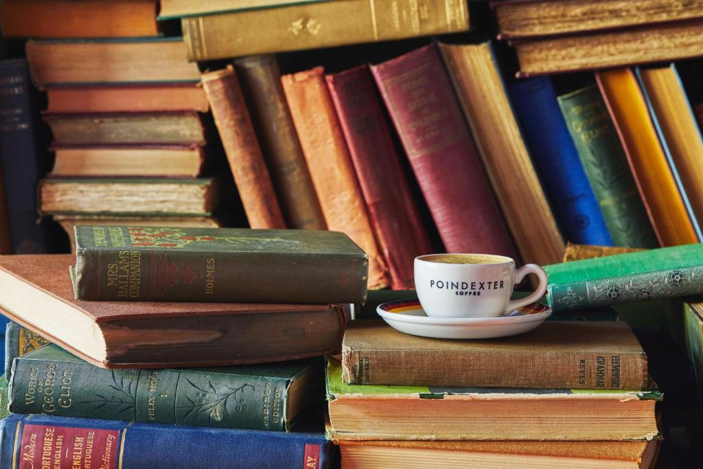 a stack of books with a cup of coffee on top at Graduate by Hilton Providence in Providence