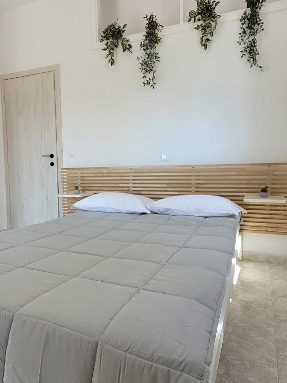 - une chambre avec un grand lit recouvert de plantes dans l'établissement Seva's House, à Rhodes