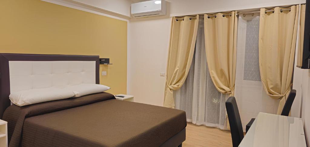 a bedroom with a bed and a window with curtains at Convenient Booking B&B in Rome