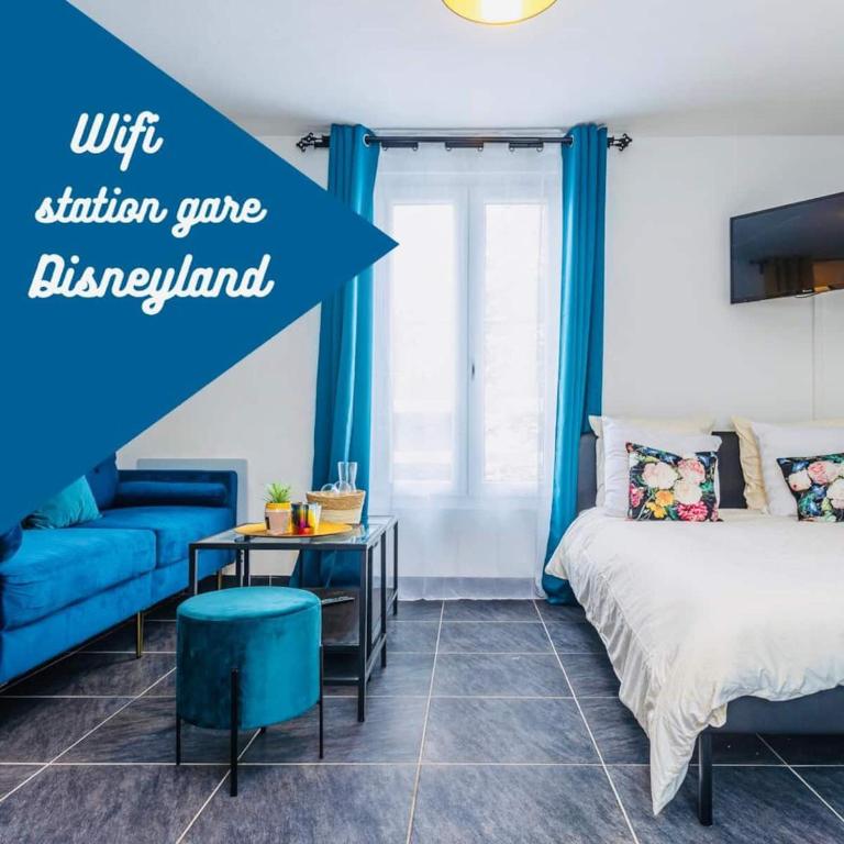 une chambre avec un lit et un canapé bleu dans l'établissement Charmant studio proche Disneyland face à la gare, à Thorigny-sur-Marne