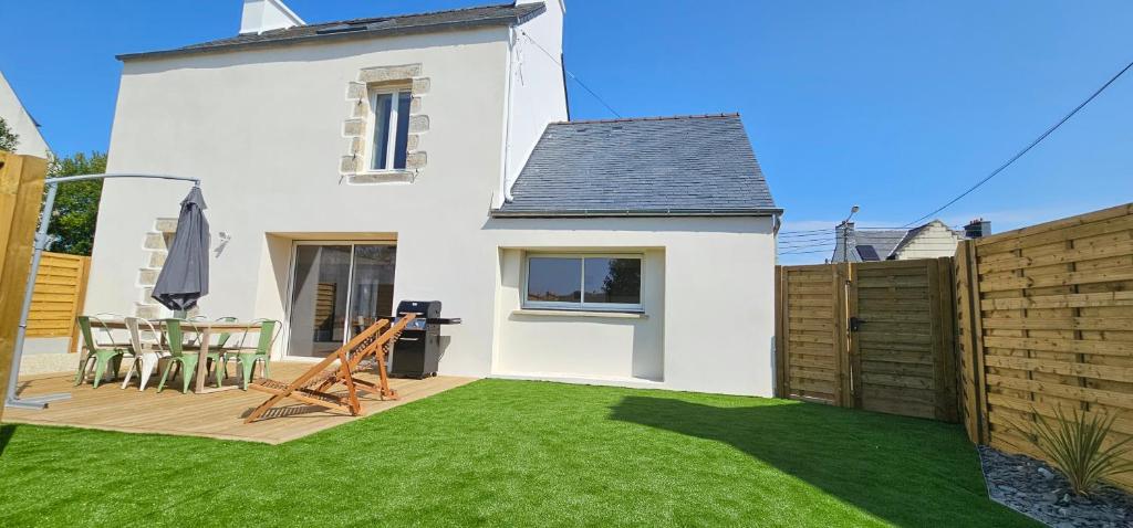 une petite arrière-cour avec une pelouse en face d'une maison dans l'établissement Jolie maison entièrement rénovée proche du bourg et des plages, à Landéda
