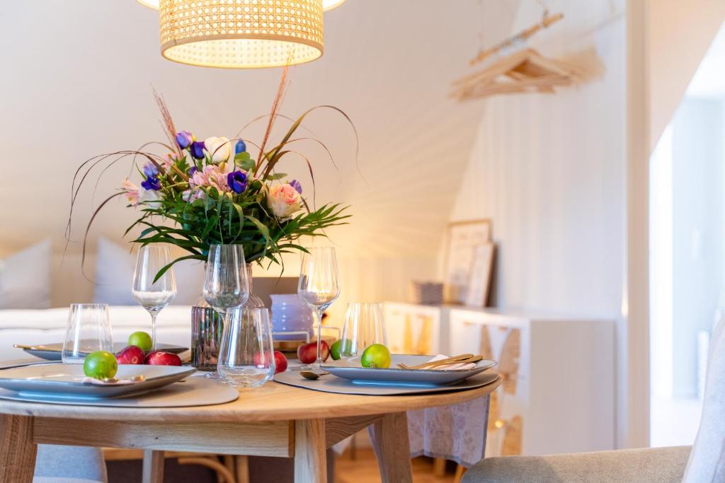 een eettafel met een vaas met bloemen erop bij Studio - Kleiner Ostsee Hof in Großenbrode
