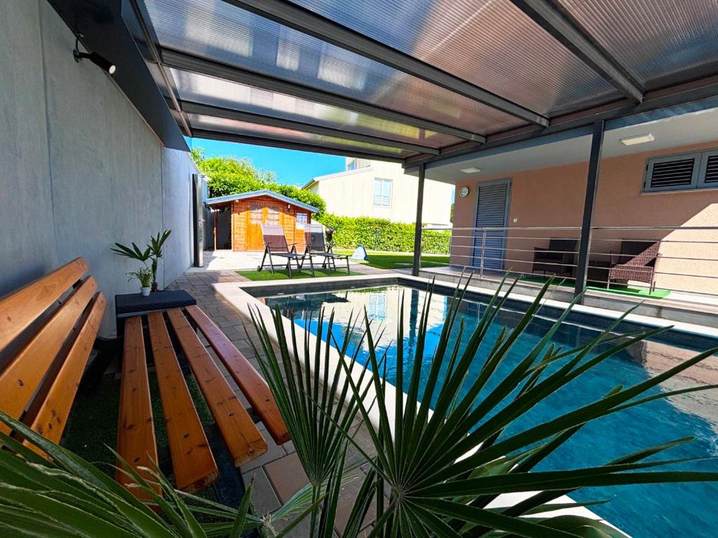 a swimming pool with a pergola and a house at Villa Dambo mit Pool , 4 Sterne in Grkavešćak