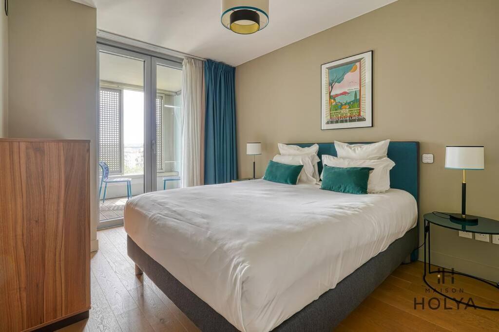 une chambre avec un grand lit avec des rideaux bleus dans l'établissement Le Lumineux - À Auteuil - 361B, à Paris