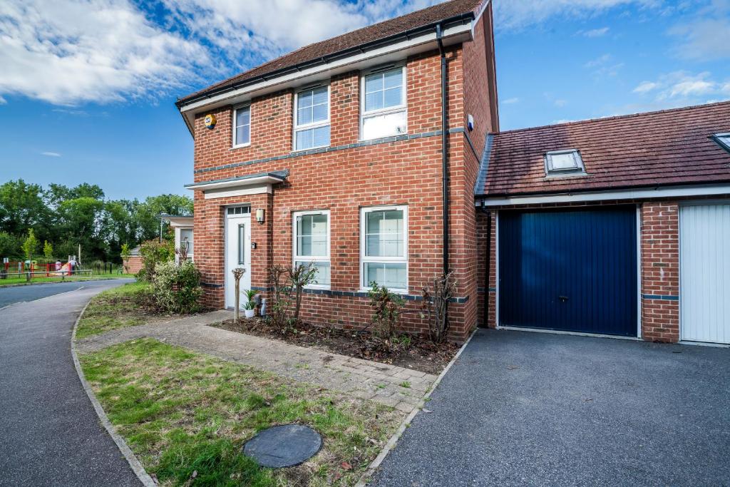 a red brick house with a blue garage at Argus Hse Contractor, Relocator, Families, Free Parking, Industrial Area in Leverstock Green