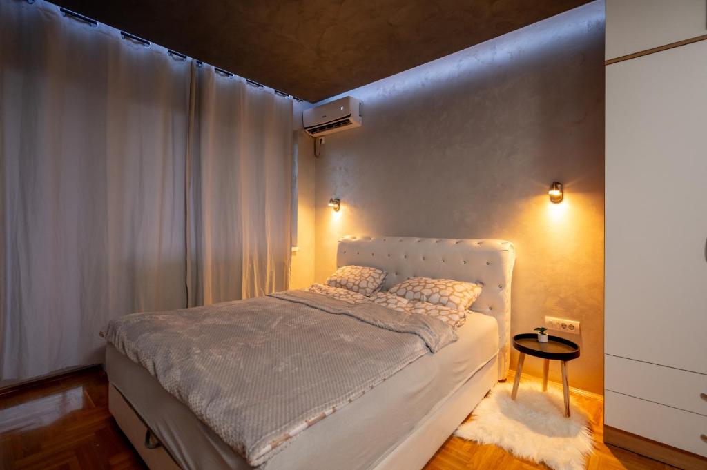 1 dormitorio con 1 cama con cabecero blanco en La Casa Studio Apartman, en Subotica