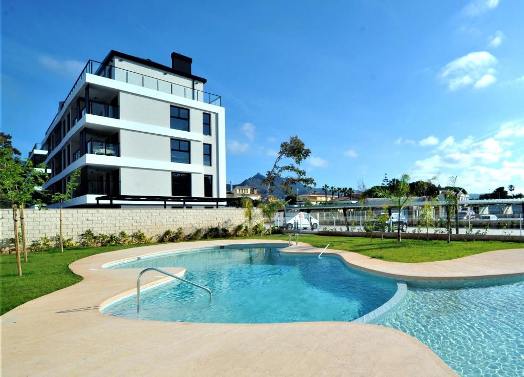 a building with a swimming pool in front of a building at ATICO BOHIO premium in Benicàssim