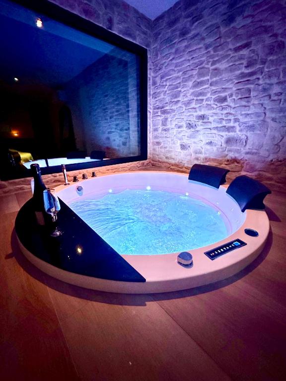 un grand jacuzzi dans une pièce avec une télévision dans l'établissement Les Suites du Payré - Suite Romance, à Saint-Hilaire-de-Talmont