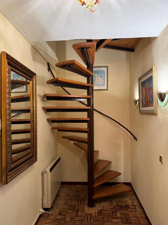 a wooden spiral staircase in a room with a wall at Duplex Arriondas in Arriondas