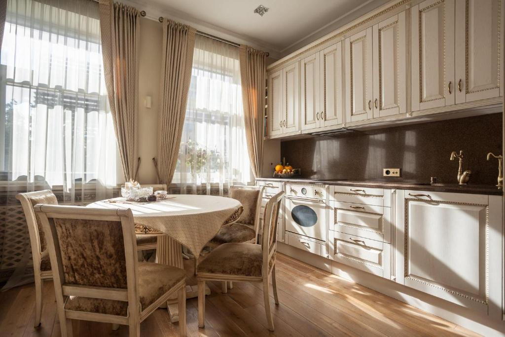 une cuisine avec une table et des chaises dans une cuisine dans l'établissement Boutique Classic Apartment in Kaunas Center, à Kaunas