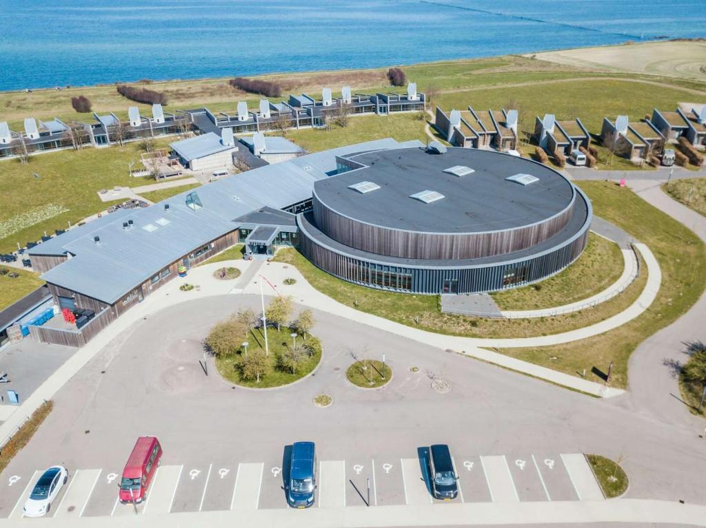 an aerial view of a building with cars parked in front at Musholm Holiday, Sport & Conference in Korsør