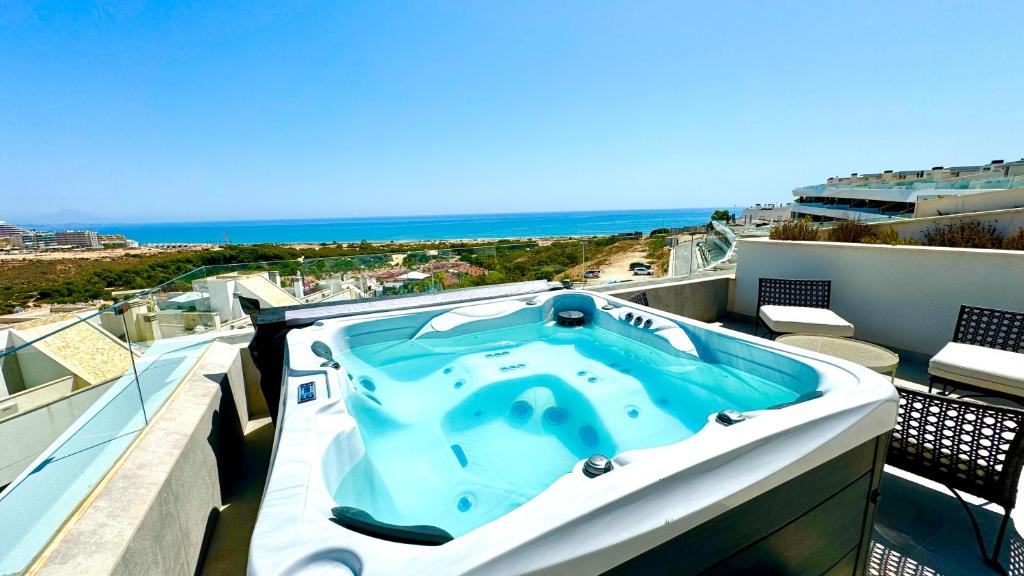 a hot tub on a balcony with a view of the ocean at 22 Aura-Piscina 3 Vistas al mar in Gran Alacant